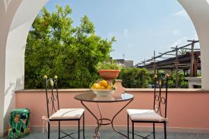 a table with a bowl of fruit on a balcony at Boutique Hotel Casa Mariantonia in Anacapri