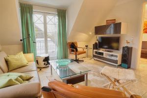 a living room with a couch and a tv at Les Belles, Haus Davide, FW Mondain, Whg 10 in Zingst