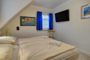 a bedroom with two beds and a flat screen tv at Les Belles, Haus Davide, FW Mondain, Whg 10 in Zingst