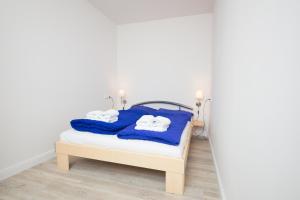 a bedroom with a bed with blue towels on it at Schleiblick App 2 in Rabenkirchen-Faulück