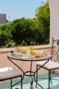 阿納卡普里的住宿－卡薩瑪麗安冬妮婭精品酒店，阳台上桌子上的托盘食物