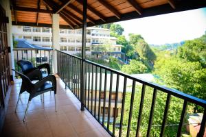 a balcony with chairs and a view of a building at Freedom Lodge, Kandy in Kandy