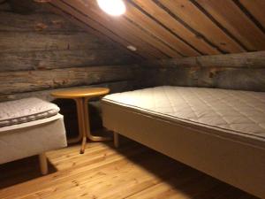 a room with a bed and a stool in a cabin at Petäjälammen Turistimajat in Kuusamo