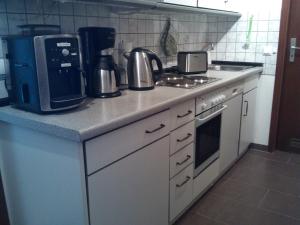 a kitchen with a counter with a coffee maker and a stove at Ferienwohnung, Steinwarder 9 in Heiligenhafen