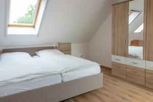 a white bedroom with a bed and a window at Huxfeld-Hof - Wümme in Grasberg