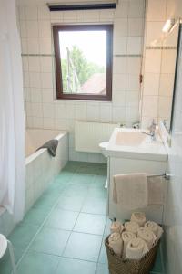 a bathroom with a tub and a sink and a bath tubermottermott at Huxfeld-Hof - Wümme in Grasberg