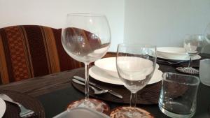 a table with two wine glasses and plates on it at Auszeit am Elbdeich in Sankt Margarethen in Sankt Margarethen