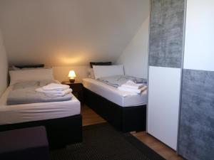 two twin beds in a small room with a lamp at Auszeit am Elbdeich in Sankt Margarethen in Sankt Margarethen