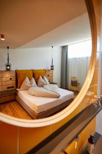 1 dormitorio con 1 cama con espejo grande en EdeR FriDa - Tuttiii KomPletti ALL inKlusiv en Maria Alm am Steinernen Meer