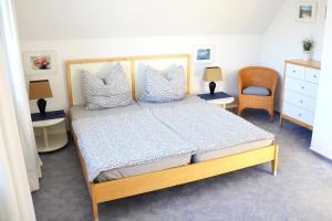 a bedroom with a large bed with pillows and a chair at Haus Birnbaum in Zingst