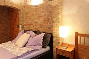 a bed with pillows on it with a brick wall at Souterrain in Potsdam