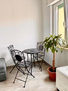 due sedie e un tavolo in una stanza con una pianta in vaso di Tres joli a Roma