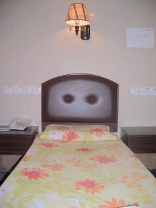 Una cama con una cabecera negra con flores. en C U Again Hostel, en Hong Kong