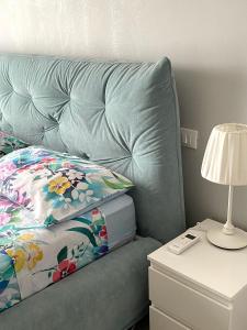 ein Bett mit einem Kissen und einer Lampe auf einem Nachttisch in der Unterkunft Tres joli in Rom