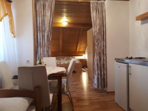 a kitchen and living room with a table and chairs at Guest House Family Varda Plitvice Lakes in Plitvička Jezera