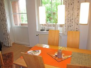 a dining room with an orange table and chairs at "Landhaus Voss" Typ 3 Nr9 in Staberdorf