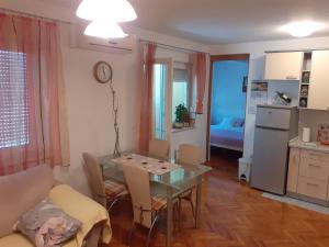 eine Küche und ein Wohnzimmer mit einem Tisch und Stühlen in der Unterkunft Apartman Mario in Osijek