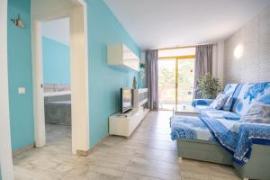 Sala de estar azul con sofá y TV en Salou-Piscina-Playa Port Aventura1, en Salou