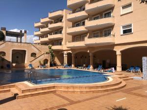 a swimming pool in front of a building at Agua marina in Playas de Orihuela