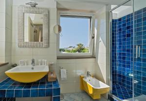 a bathroom with a large yellow tub and a sink at Boutique Hotel Casa Mariantonia in Anacapri