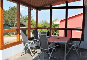 a patio with a table and chairs on a porch at Blaues Haus mit Meerblick in Hohenkirchen