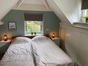 a large bed in a room with a window at Bosboerderij de Veluwe, luxe huisje in het bos in Lunteren +20 photos