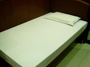 a white bed with a pillow on top of it at Li’s Chain Hostel in Hong Kong