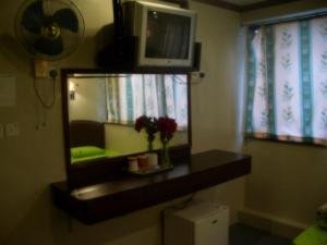 a bathroom with a mirror and a vase of flowers at Li’s Chain Hostel in Hong Kong