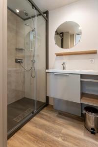 a bathroom with a shower and a sink and a mirror at Düne 58 in Scharbeutz