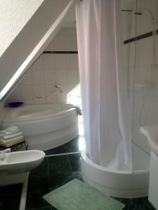 ein Bad mit einer Badewanne, einem Waschbecken und einer Dusche in der Unterkunft Ferienhaus Rüder "Schöne Aussicht" in Avendorf auf Fehmarn