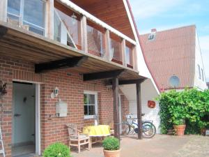 un porche de una casa de ladrillo con mesa y sillas en Ferienhaus Rüder "Schöne Aussicht", en Avendorf auf Fehmarn