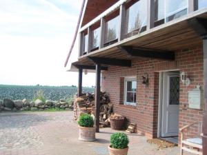 ein Backsteinhaus mit einer Veranda und einer Tür in der Unterkunft Ferienhaus Rüder "Schöne Aussicht" in Avendorf auf Fehmarn