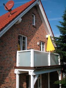 a balcony on the side of a brick house at Ferienwohnung Bünz in Schülp