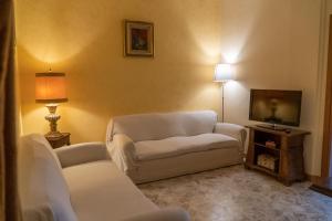 a living room with two white chairs and a television at Via Sparano Suite in Bari