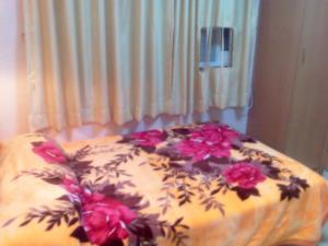 ein Bett mit Blumen auf einem Zimmer in der Unterkunft Oriental Pearl Budget Hotel in Hongkong