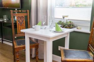 - une table et des chaises blanches dans la salle à manger dans l'établissement Gästehaus "Alte Bücherei" Satrup - a50559, à Mittelangeln