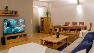 uma sala de estar com um sofá, uma televisão e uma mesa em Villa - Ettenheim em Ettenheim