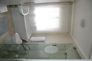 a bathroom with a glass counter with a toilet and a window at The Winelands Guest House in Bellville