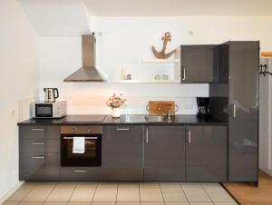 a kitchen with gray cabinets and a sink at Ferienwohnungen Marienthal in Hamburg