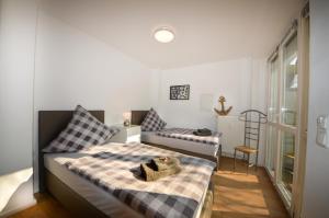 ein kleines Schlafzimmer mit einem Bett und einem Stuhl in der Unterkunft Ferienwohnungen Marienthal in Hamburg