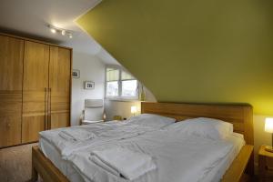 a bedroom with a large bed and a chair at Dat suutsche Huus in Zingst