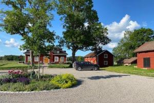 a car parked in a driveway in front of a house at Albäck Gård Bagarstugan - Granne med Sala Golfklubb in Sala