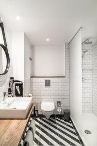 uma casa de banho com um lavatório branco e um WC. em pentahotel Wiesbaden em Wiesbaden