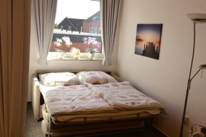 ein kleines Schlafzimmer mit einem Bett und einem Fenster in der Unterkunft Fewo 91 WHG C 11 in Burhave in Burhave