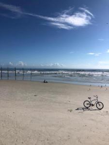 una bicicletta seduta sulla spiaggia vicino all'oceano di Cove Motel Oceanfront a Daytona Beach