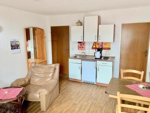 a living room with a couch and a kitchen with a table at Ferienhof Frohne - Up de Hielen in Merzen