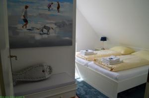 um quarto com duas camas e um quadro na parede em Hüs Neiwoi em Borgsum