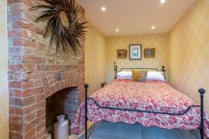 a bedroom with a bed and a brick fireplace at Little Coach House in Beckley