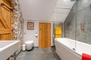 a bathroom with a tub and a toilet at Little Coach House in Beckley +17 photos