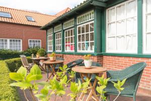 un patio con mesas y sillas frente a un edificio en Haus Gerd Janssen Wohnung 1, en Spiekeroog